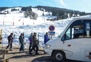 Des skieurs en train de monter dans une navette au pied des pistes 