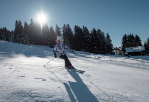 Une femme skie en bord de forêt