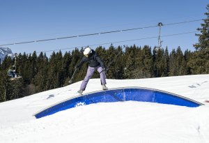 Skieur qui glide sur un module du snowpark